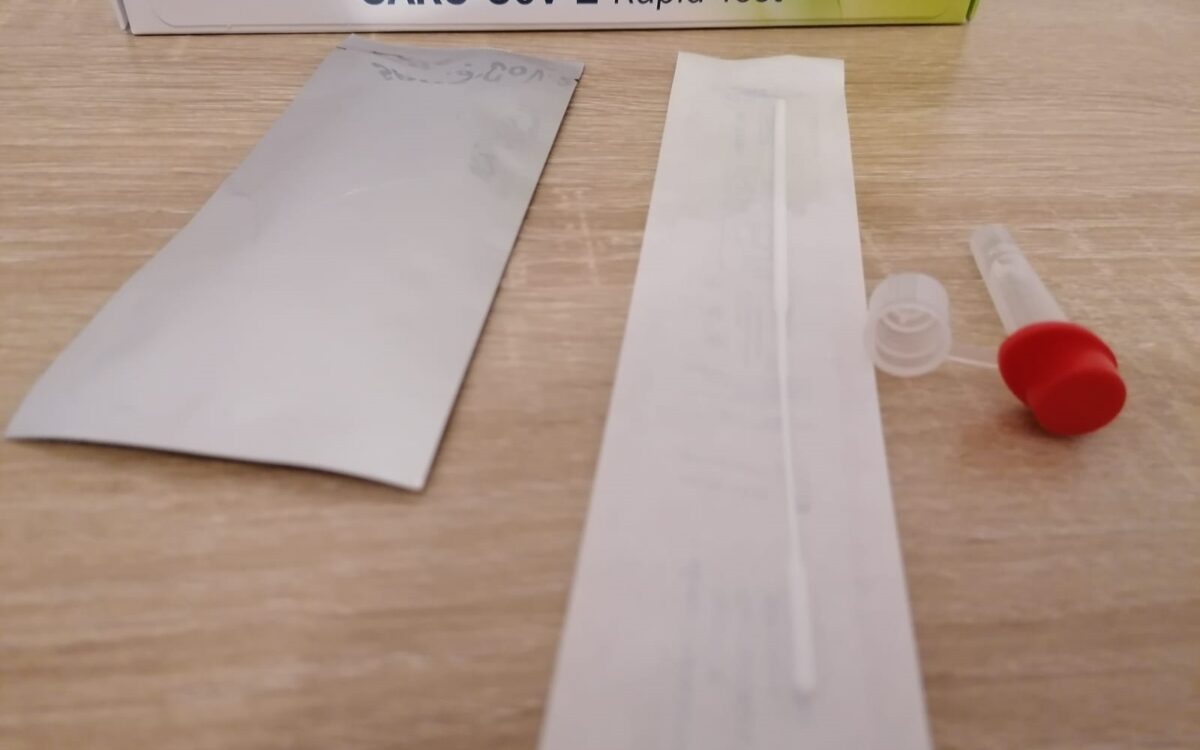 Ein Corona Selbsttest liegt auf dem Tisch mit Stäbchen und Flüssigkeit Ein Corona Selbsttest liegt auf dem Tisch mit Stäbchen und Flüssigkeit